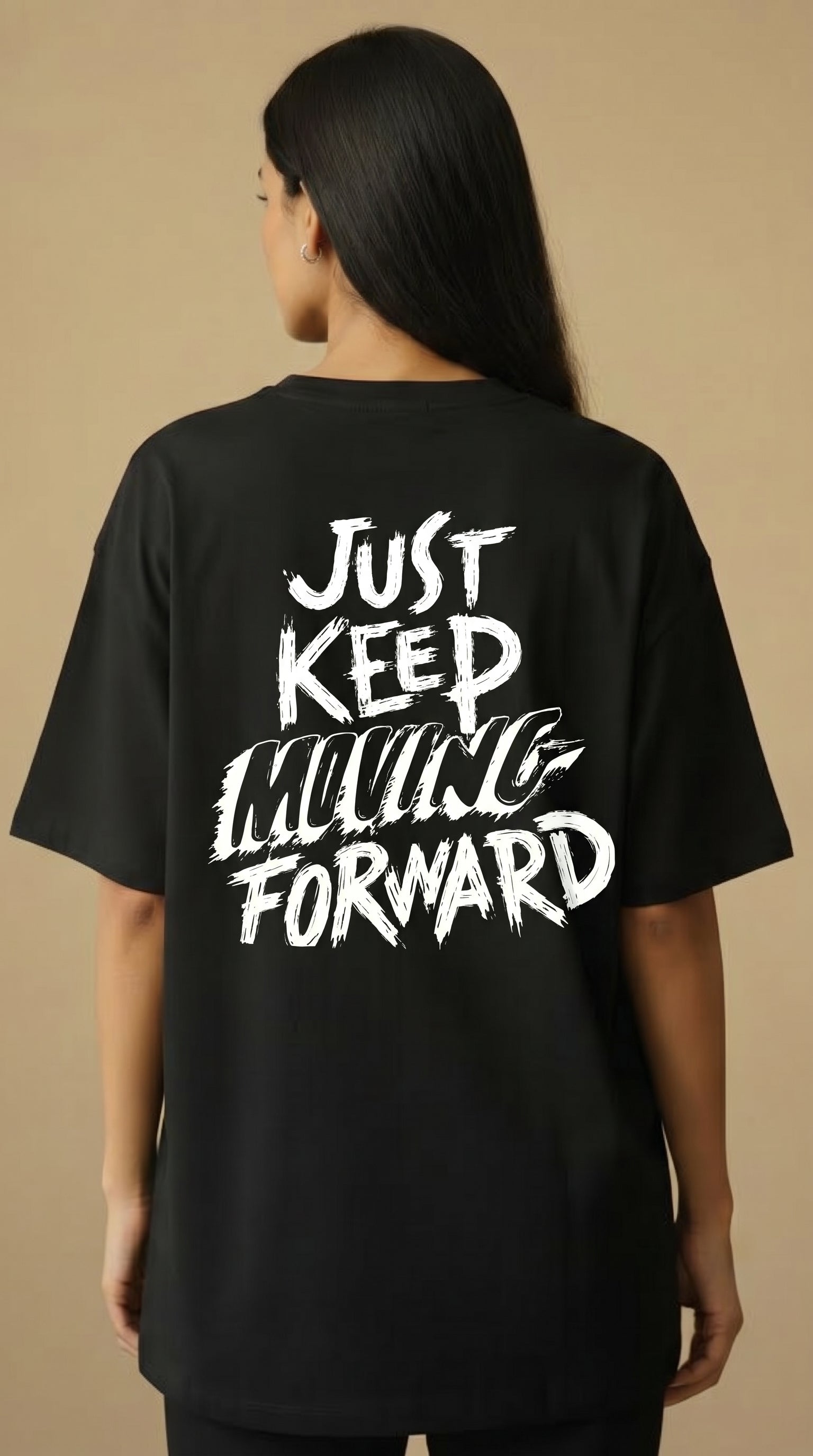 Person wearing a black t-shirt with 'Just Keep Moving Forward' text on the back against a beige background